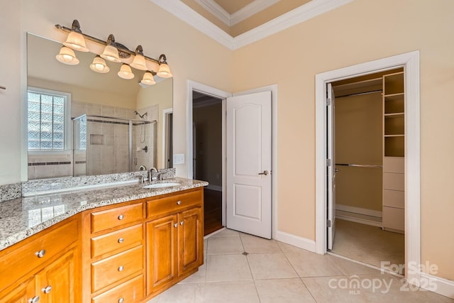 bathroom with an enclosed shower, vanity, crown molding, and tile patterned flooring