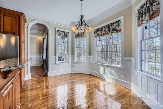 unfurnished dining area featuring hardwood / wood-style floors and ornamental molding