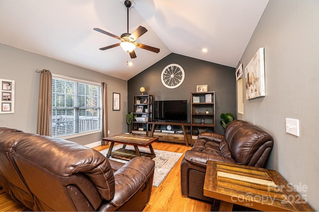 living room with ceiling fan, light hardwood / wood-style flooring, and vaulted ceiling