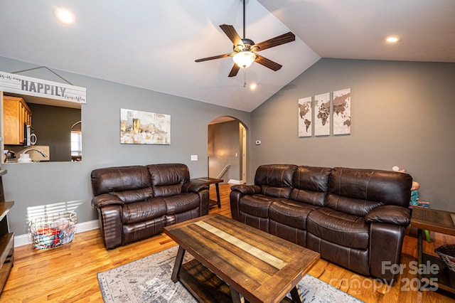 living room featuring lofted ceiling, light hardwood / wood-style floors, and ceiling fan