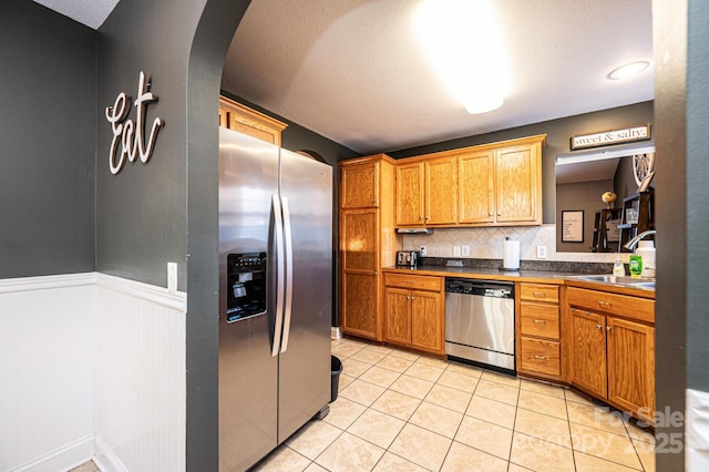 kitchen featuring light tile patterned floors, sink, decorative backsplash, and appliances with stainless steel finishes