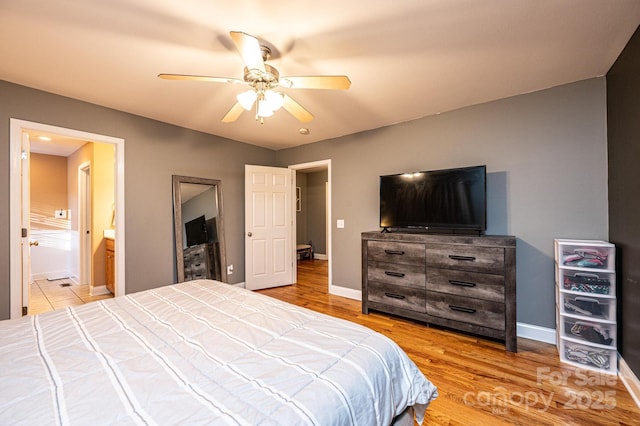 bedroom featuring ceiling fan, light hardwood / wood-style floors, and ensuite bath