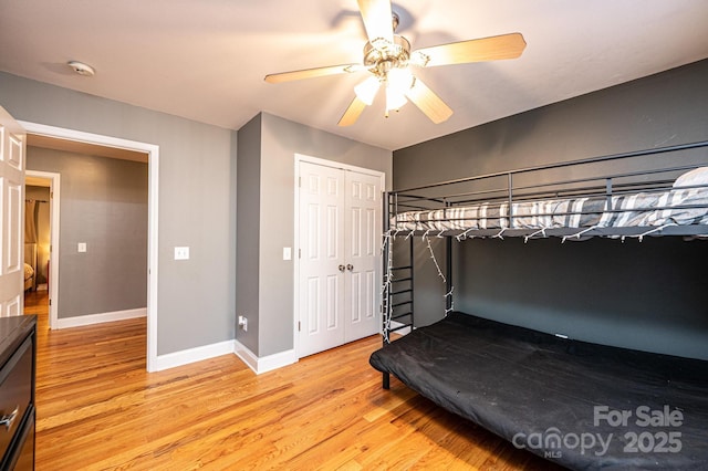 bedroom featuring ceiling fan, light hardwood / wood-style floors, and a closet