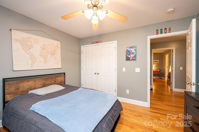 bedroom featuring ceiling fan, a closet, and light wood-type flooring