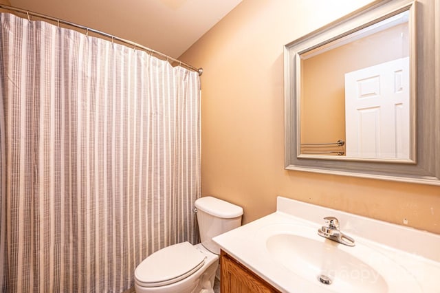 bathroom with toilet, vanity, and a shower with shower curtain