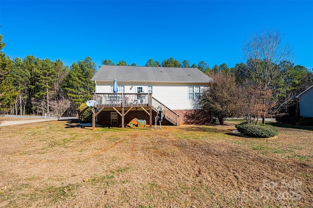 rear view of house with a lawn and a wooden deck