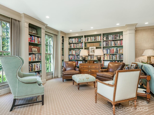 sitting room with carpet floors, bookshelves, ornamental molding, and recessed lighting