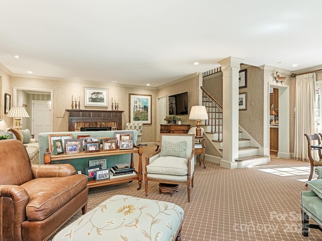 carpeted living area featuring a brick fireplace, baseboards, stairway, and crown molding