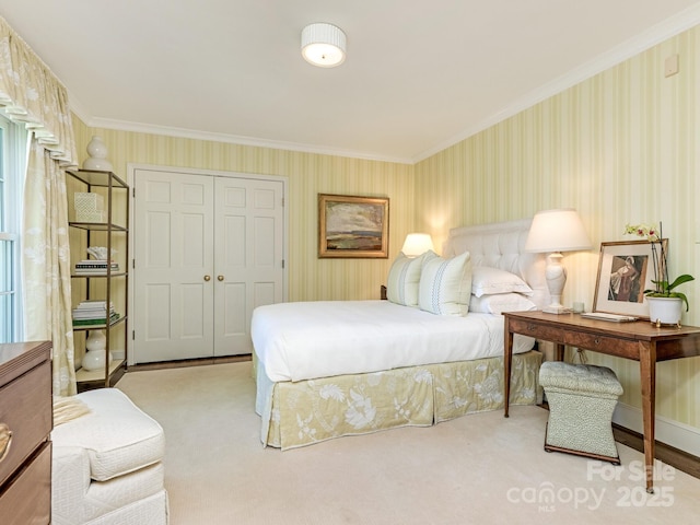 bedroom with wallpapered walls, crown molding, and a closet