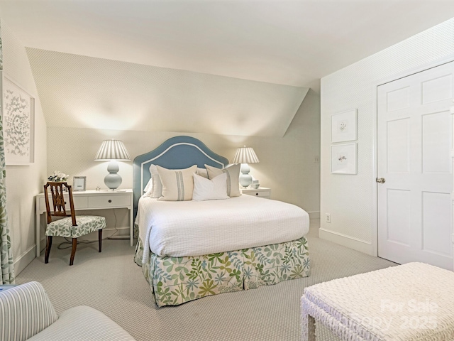 bedroom featuring lofted ceiling, baseboards, and carpet flooring