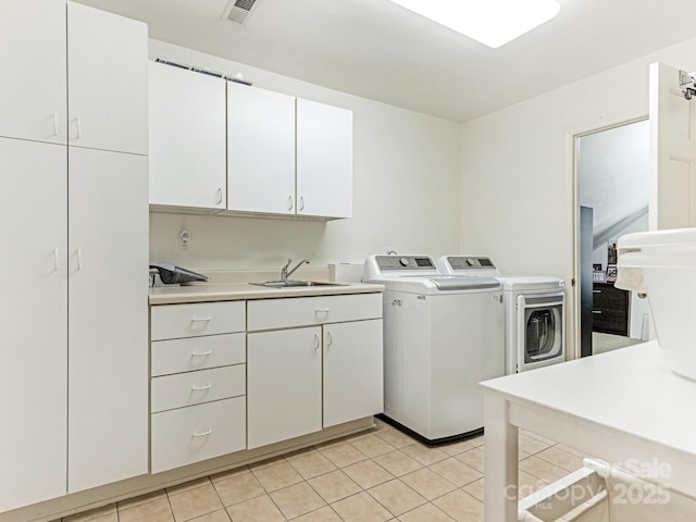 laundry area with light tile patterned floors, washing machine and dryer, a sink, visible vents, and cabinet space