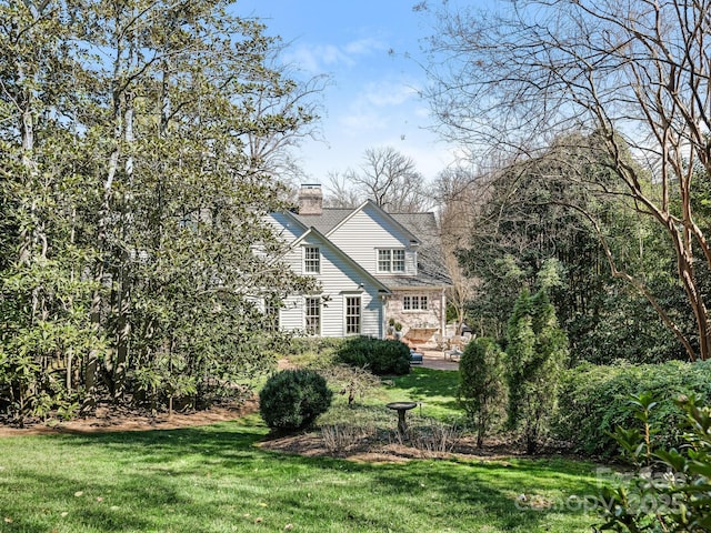 view of front of property featuring a chimney and a front yard