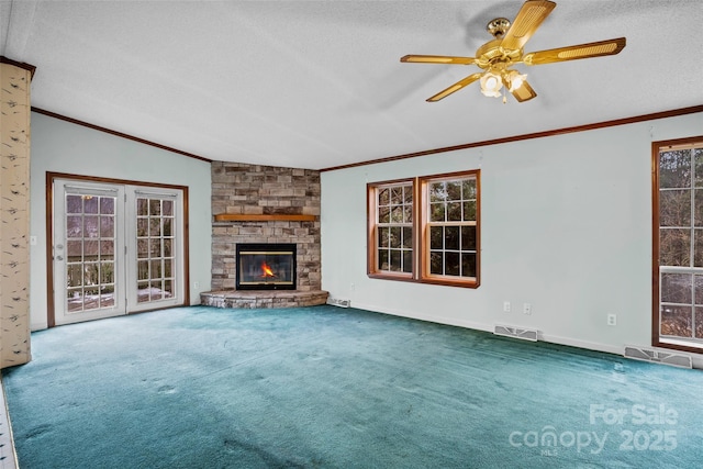 unfurnished living room with crown molding, a stone fireplace, carpet, and a textured ceiling