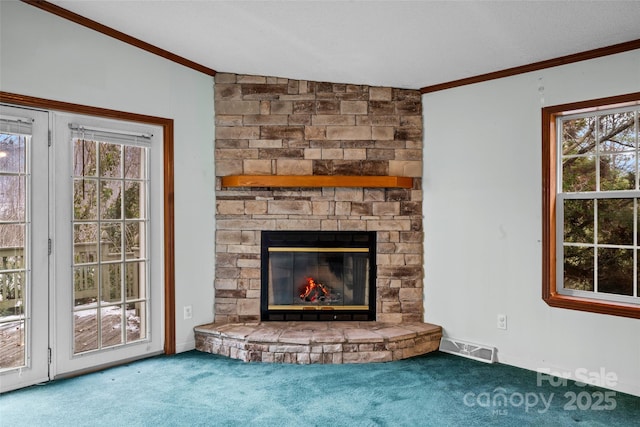 unfurnished living room with ornamental molding, a large fireplace, and carpet