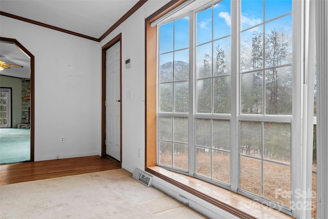 carpeted empty room featuring ornamental molding and ceiling fan