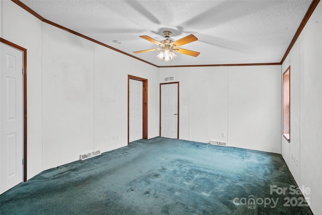 spare room with dark carpet, ornamental molding, and a textured ceiling