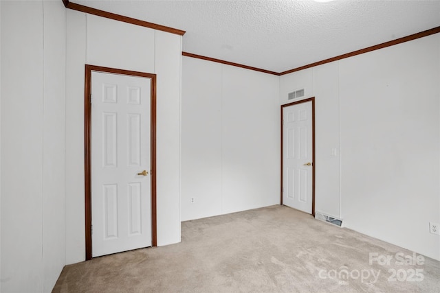 carpeted spare room with crown molding and a textured ceiling