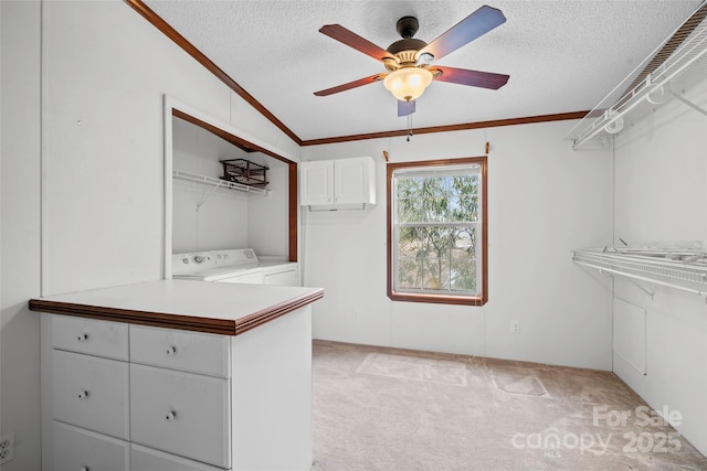 walk in closet featuring vaulted ceiling, ceiling fan, washing machine and dryer, and light carpet