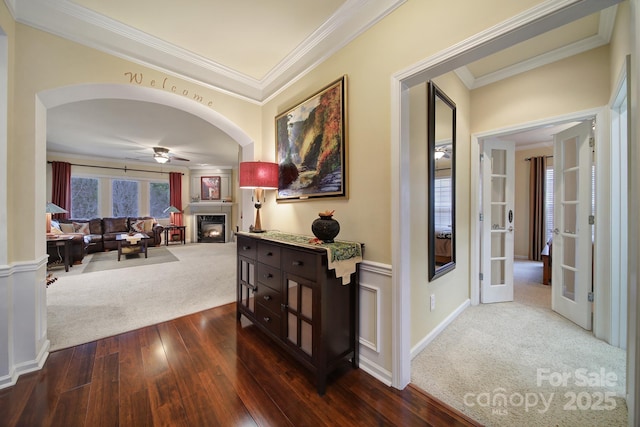 hall with ornamental molding and dark carpet