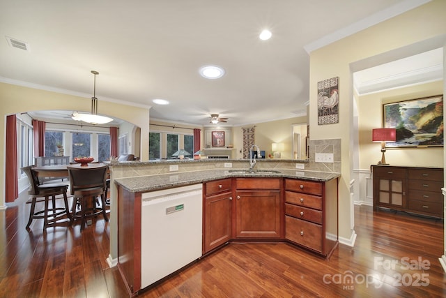 kitchen featuring sink, hanging light fixtures, white dishwasher, dark hardwood / wood-style flooring, and stone counters