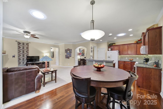 dining room featuring crown molding, dark wood-type flooring, and ceiling fan