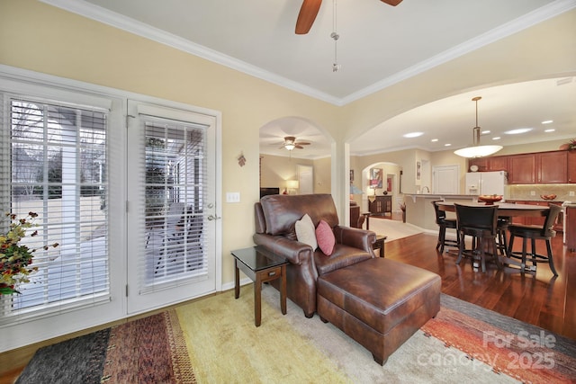 living room with ceiling fan, ornamental molding, and light hardwood / wood-style flooring