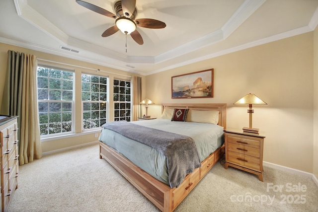 bedroom with ceiling fan, light colored carpet, ornamental molding, and a raised ceiling