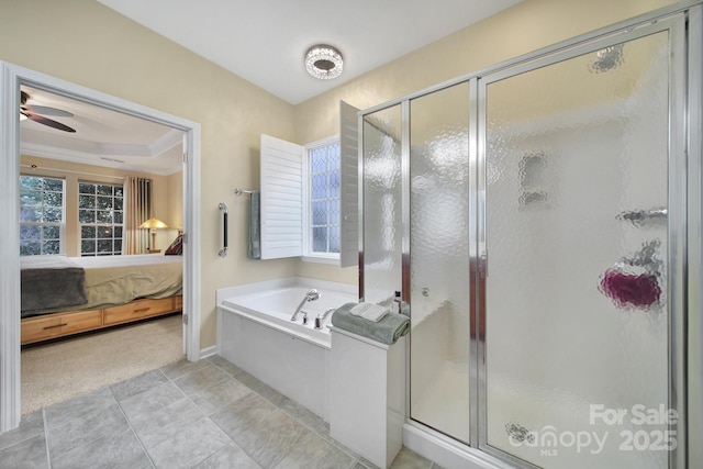 bathroom with independent shower and bath, tile patterned floors, ceiling fan, and a tray ceiling