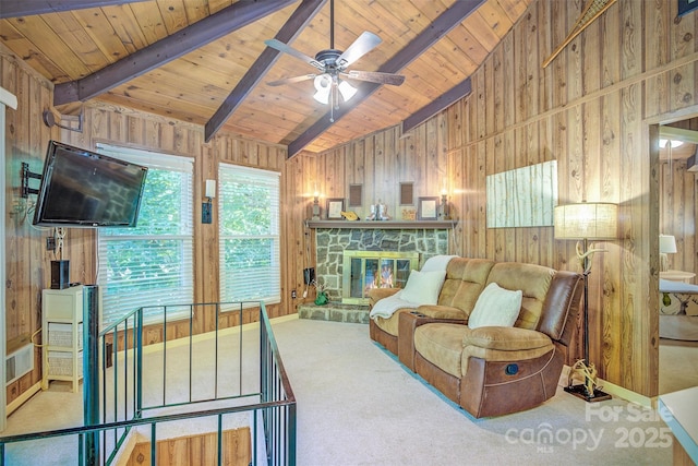 carpeted living room with vaulted ceiling with beams, a fireplace, wood walls, and wooden ceiling