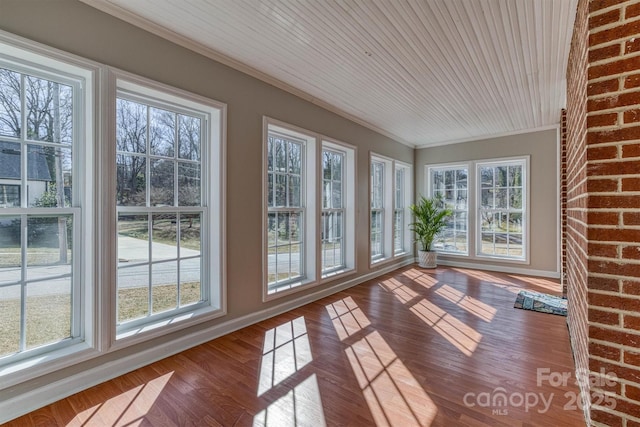 unfurnished sunroom featuring wood ceiling and plenty of natural light