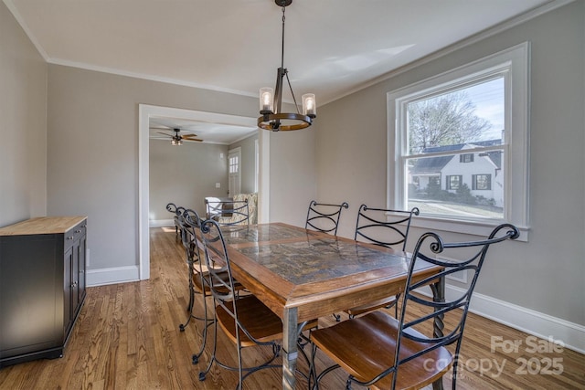 dining space featuring hardwood / wood-style flooring, crown molding, and a chandelier