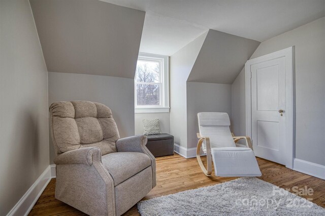 sitting room featuring hardwood / wood-style flooring and vaulted ceiling