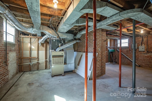 basement with brick wall and heating unit