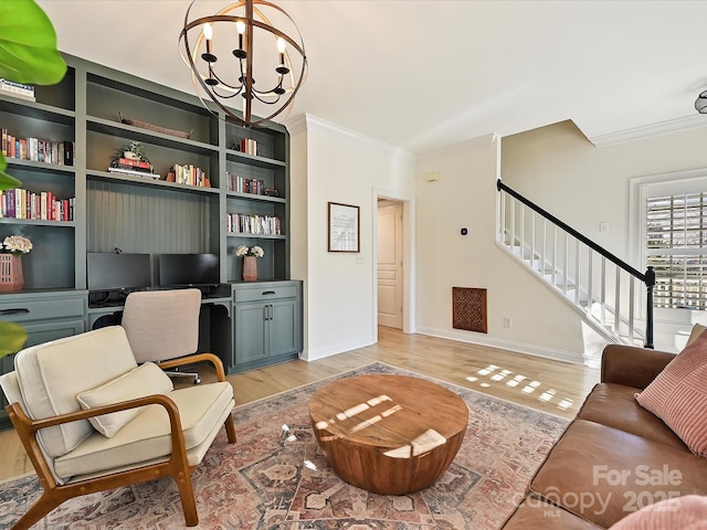 living room with built in shelves, ornamental molding, an inviting chandelier, and light wood-type flooring