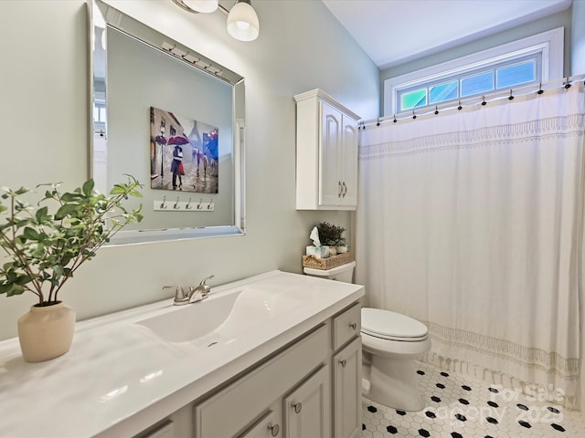 bathroom with curtained shower, toilet, tile patterned floors, and vanity