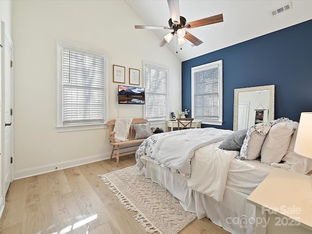 bedroom with ceiling fan, light hardwood / wood-style flooring, and lofted ceiling