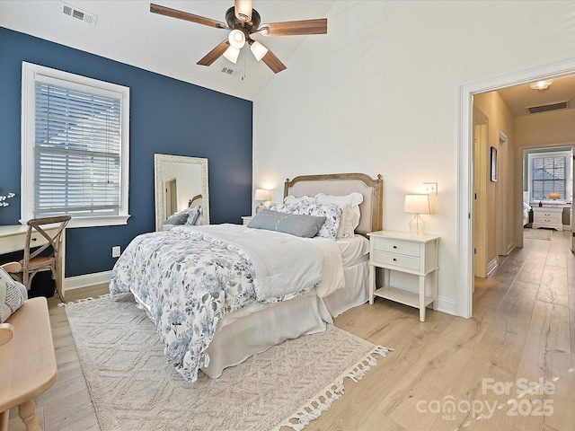 bedroom with ceiling fan, light hardwood / wood-style flooring, and lofted ceiling