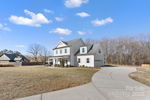 view of front of house featuring a garage, a front lawn, and a porch