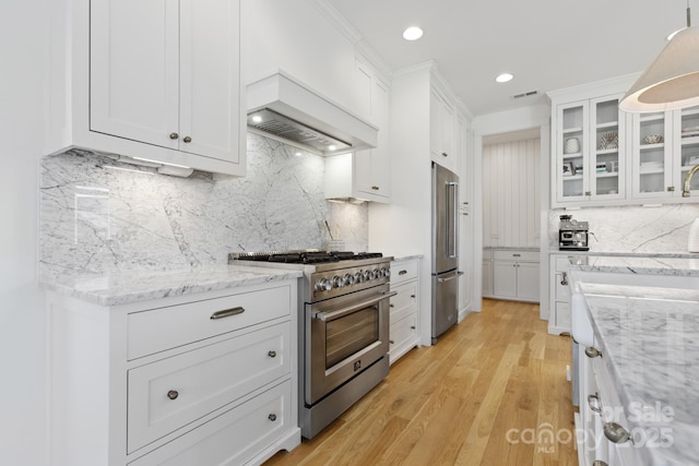 kitchen featuring white cabinets, decorative backsplash, and high quality appliances