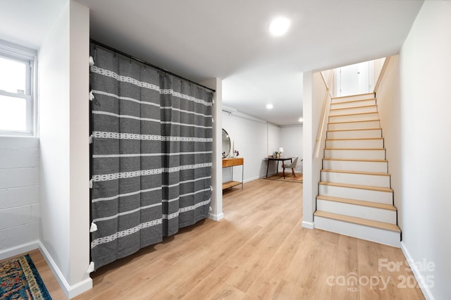 stairway featuring recessed lighting, baseboards, and wood finished floors