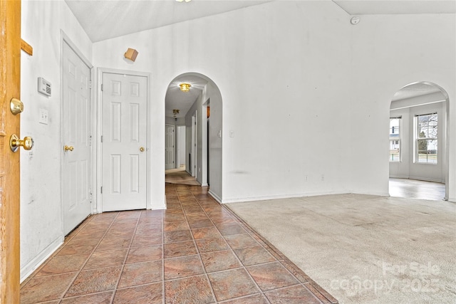 interior space featuring dark colored carpet and vaulted ceiling