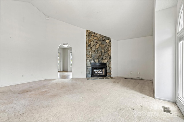 unfurnished living room with light colored carpet, a fireplace, and lofted ceiling