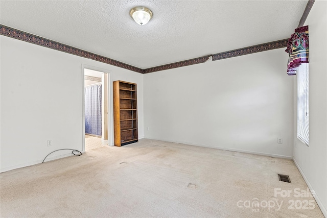 carpeted empty room with a textured ceiling