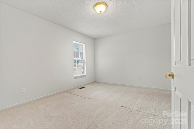 carpeted spare room featuring a textured ceiling