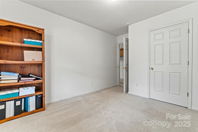 unfurnished bedroom featuring light carpet and a textured ceiling