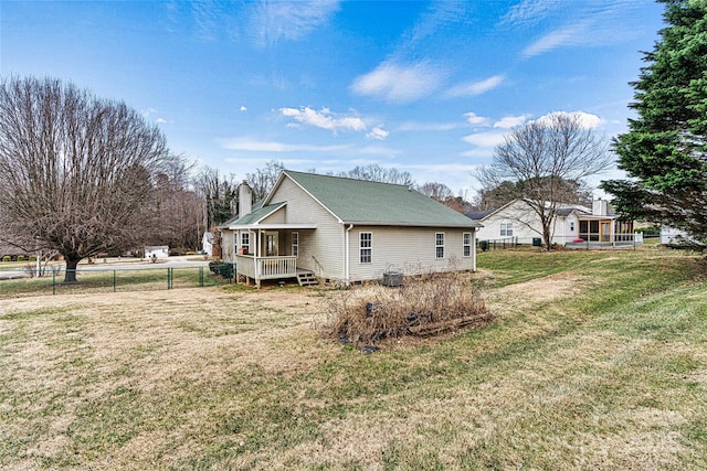 view of side of property with covered porch and a yard