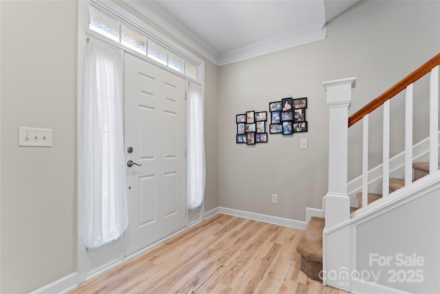 entryway with crown molding and light hardwood / wood-style floors