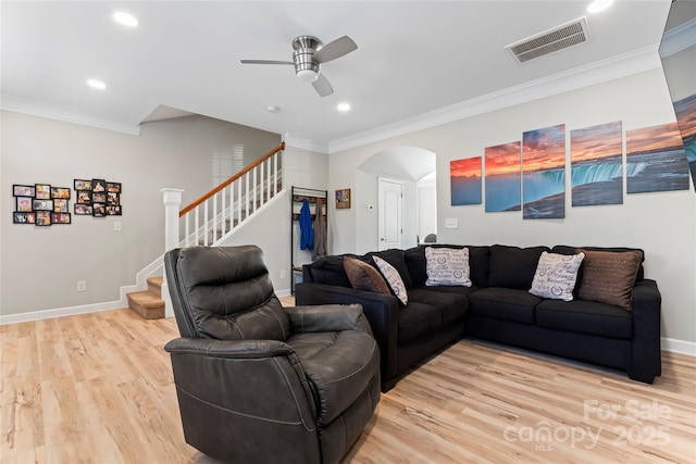 living room with crown molding, ceiling fan, and light wood-type flooring