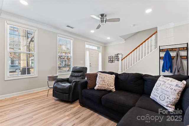 living room featuring ornamental molding, ceiling fan, and light wood-type flooring