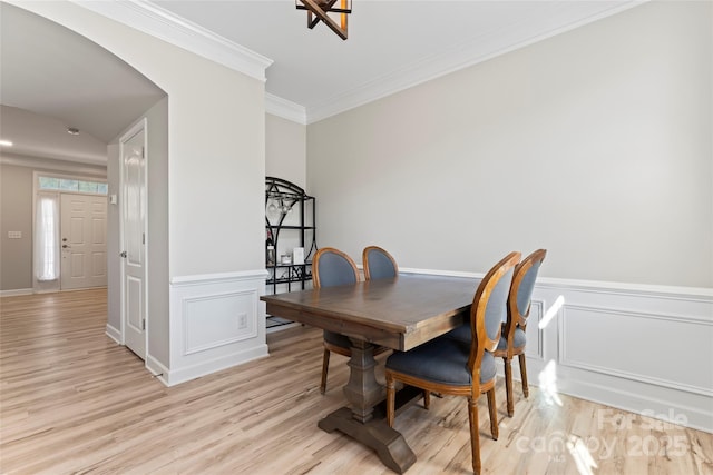 dining space with crown molding and light wood-type flooring